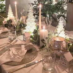 the table is set with silverware, candles and napkins for christmas dinner guests