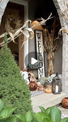 a front porch decorated for fall with pumpkins and corn stalks