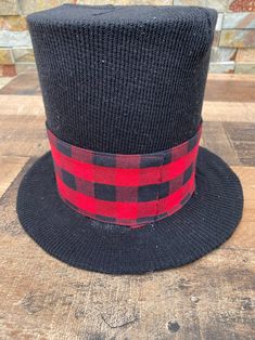 a black and red hat sitting on top of a wooden table