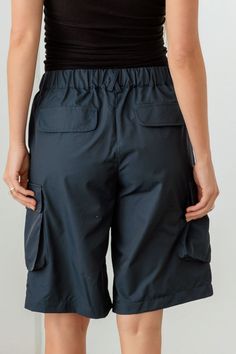 Stay cool and stylish in these Navy Cargo Bermuda Shorts. Perfect for your casual summer days, these shorts offer a laid-back yet trendy look. The cargo style adds a touch of utility and practicality, perfect for keeping essentials close at hand. The navy color is versatile and easy to pair with all your favorite tops. Whether you're running errands or enjoying a day at the beach, these Bermuda shorts are a must-have for your warm-weather wardrobe. Pair them with a tank top and sandals for a rel Utility Bermuda Bottoms With Built-in Shorts, Utility Bermuda Shorts With Built-in Shorts, Short Cargo Pants With Built-in Shorts For Summer, Outdoor Cargo Pocket Bermuda Shorts, Outdoor Cargo Bermuda Shorts, Summer Outdoor Short Length Cargo Pants, Summer Utility Bermuda Knee-length Shorts, Summer Bottoms With Cargo Pockets, Utility Bermuda Knee-length Shorts For Summer