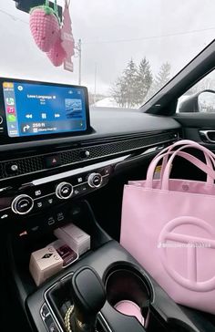 a pink purse sitting on top of a car dashboard