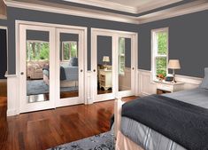 a bedroom with blue walls and white trim on the doors, windows, and bed