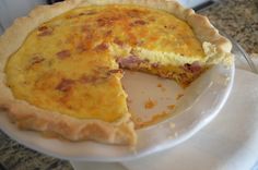 a quiche on a plate with one slice missing