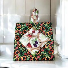 a colorful handbag hanging on a tiled wall