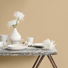 a table topped with white dishes and vases