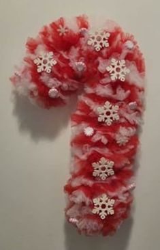 a red and white scarf with snowflakes hanging from it's side on a wall