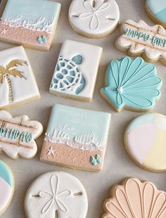 some decorated cookies are laying on a tray with sand dollar signs and seashells