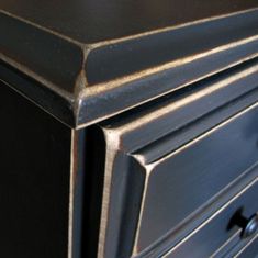 a black dresser with two drawers and knobs