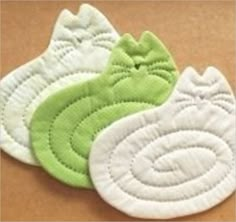 three green and white appliques sitting on top of a wooden table next to each other