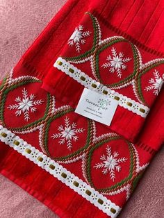 two red christmas sweaters with white snowflakes on them and a price tag