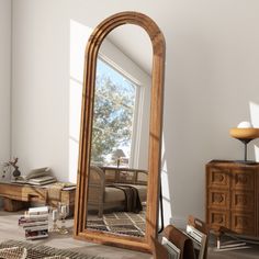 a large mirror sitting on top of a wooden floor next to a dresser and chair