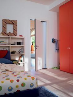 a bedroom with a bed, bookshelf and closets in the corner next to it