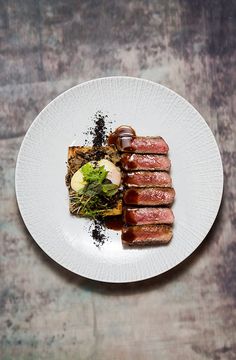 a white plate topped with meat and vegetables