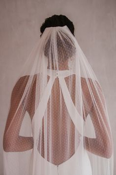 the back of a bride's veil with white polka dots on it is shown