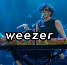 a woman standing on top of a keyboard with the words weezer in front of her