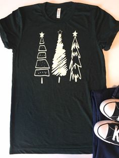 Christmas Shirt. Womens Christmas Shirt. Christmas Tree Tee. Christmas T-Shirt. Christmas Tees. Holiday Shirts. Christmas Graphic Tee. Everyone needs a favorite tee. This tee can be just that. This one has a cute tree design screen printed with off white ink on a heather emerald green tee. It's soft, comfortable, and stylish. Grab one for yourself or your friend who loves Christmas! Christmas Tree Tee Bella/Canvas brand Unisex Fitted Tee, 4.2 oz 100% Combed and ringspun cotton The tee is heather Emerald Green Christmas, Holiday Shirt Ideas, Christmas Tee Shirts, Fun Shirts, Christmas Vinyl, Womens Christmas Shirts, Womens Christmas, Mommy Shirts, Christmas Graphic