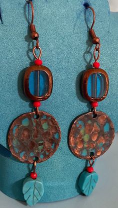 Components  Rustic Handcrafted Copper  Turquoise Leaves Red Seed Beads Copper Edged Aqua Glass Antiqued Copper Wires  LIGHTWEIGHT AND EYE CATCHING! Turquoise brings inner calm, creativity,joy and a lightness in communication.  It's Native belief that COPPER is a conduit to the Great Spirit. WEAR IN GOOD HEALTH! Blue Earrings With Colorful Metal Beads, Red Bohemian Soldered Earrings, Bohemian Red Soldered Earrings, Blue Copper Round Bead Jewelry, Blue Round Bead Copper Jewelry, Blue Copper Round Beads Jewelry, Blue Beaded Copper Jewelry, Nickel-free Red Earrings For The Beach, Red Round Beach Earrings