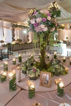 the centerpiece is surrounded by candles and flowers