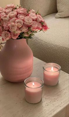 pink roses in a vase and candles on a table