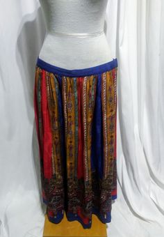 Vintage Red, Blue and Yellow Multi colored skirt. Fantastic ankle length skirt with brilliant patterns and colors. Blue waistband with vertical panels each of a different color-Red, Blue and Yellow, flanked by White or Gold and decorated with tiny flowers. Trimmed with a paisley pattern at the hem. Light. Long and flowing. Made of silk. Very bohemian vibe. Zipper and button closure at back waist. Umi Collections by Anne Crimmins. Size 12. Multicolor Harem Skirt, Bohemian Multicolor Skirt With Elastic Waistband, Bohemian Red Flared Skirt Bottoms, Bohemian Red Flared Skirt, Folk Style Long Lined Skirt, Red Bohemian Relaxed Skirt, Traditional Red Flowy Maxi Skirt, Red Full Skirt With Elastic Waistband, Traditional Flowy Red Maxi Skirt