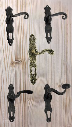 an assortment of ornate iron handles on wooden planked wall with wood paneling in the background