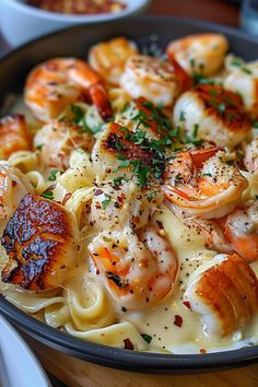 a plate of pasta with shrimp and sauce