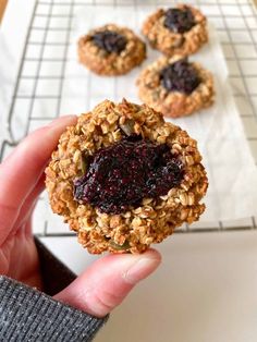 a person holding up a cookie with fruit on it