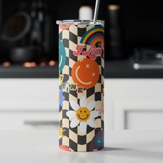 a colorful tumbler cup sitting on top of a kitchen counter next to a stove