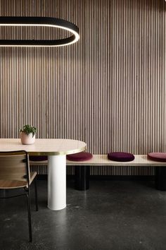 a table and chairs are in front of a wall with vertical striped panels on it