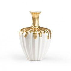 a white and gold vase sitting on top of a table