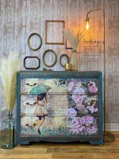 an old dresser has been painted with flowers and umbrellas on the top, along with other decorative items