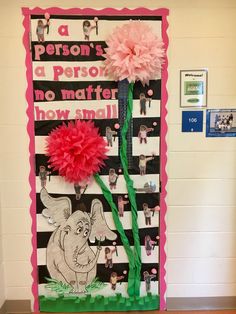 a bulletin board decorated with pink flowers and green ribbon on the front, along with an elephant theme