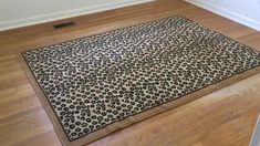 a leopard print rug is on the floor in an empty room with hard wood floors