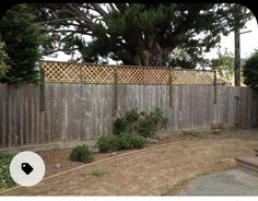 a wooden fence in front of a tree