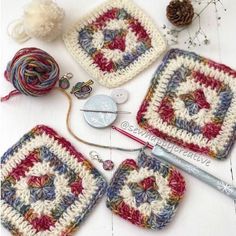 crocheted grannys are arranged on a table with yarn, needles and buttons