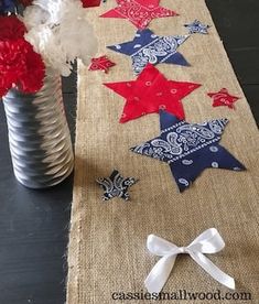 some red, white and blue flowers in a vase on a table with burlap