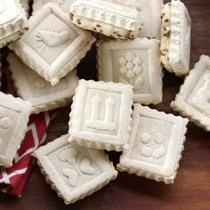 some white cookies with designs on them sitting on a table next to a red and white towel