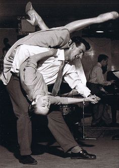 an old photo of two people dancing together