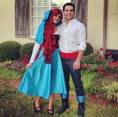 a man and woman dressed up in costumes posing for a photo outside their house,