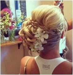 the back of a woman's head, with flowers in her hair and an instagram