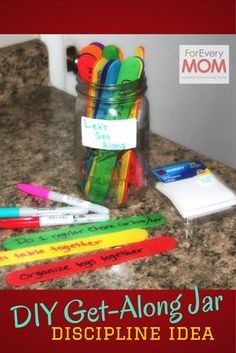 a jar filled with markers and pens sitting on top of a counter