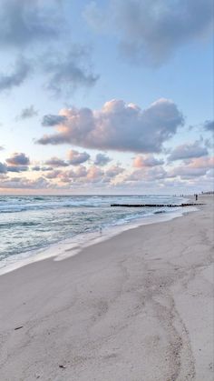 an empty beach with waves coming in from the ocean