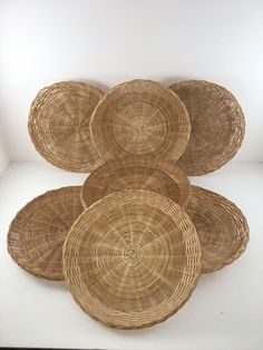 five wicker baskets stacked on top of each other in front of a white wall