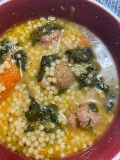 a red bowl filled with soup and vegetables