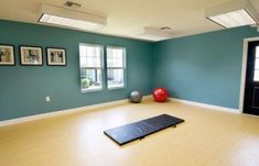 an empty room with yoga mat and exercise balls