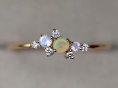 Opal Cluster Ring, Cluster ring, rainbow moonstone ring, Fire opal ring, Tiny diamond cluster ring, Diamond Opal RingAvailable in 9k/14k yellow, rose or white gold. Same design can be made also with other custom gemstones per request. Product details:- Solid gold- Diamond - 1.5mm, moonstone - 2mm, 2.5mm, opal 3mm - 1.1mm band- Made to order - 8 to 10 business days.Ring size - US 3 to US 9 (for smaller or larger ring size, please contact)Please select your size at the drop down menu. Service Avai Opal Cluster Ring, Aquamarine Stacking Ring, Engagement Ring Cluster, Aqua Ring, Ring Cluster, Opal Engagement Ring, Baguette Diamond Rings, Diamond Stacking Rings, Ring Opal