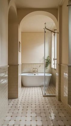 a bathroom with an arched doorway leading to the bathtub and shower area is shown