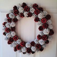 a wreath made out of pine cones and flowers