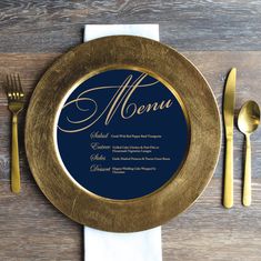 a gold plate with a blue menu on it next to silverware and forks, along with a white napkin