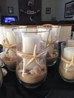 candles and starfish in glass containers on a table